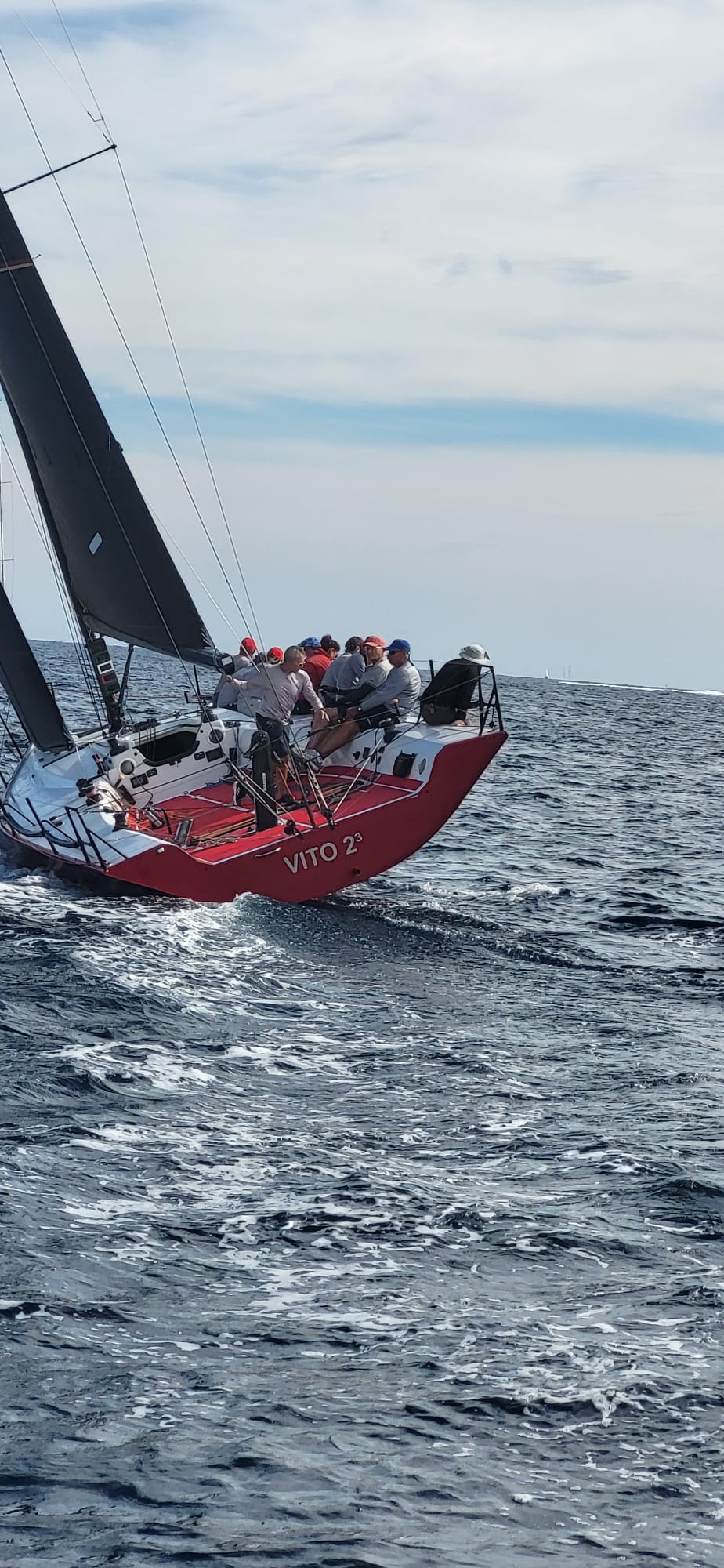 Red racing yacht VITO 2³ heeling over in open water off Saint-Tropez