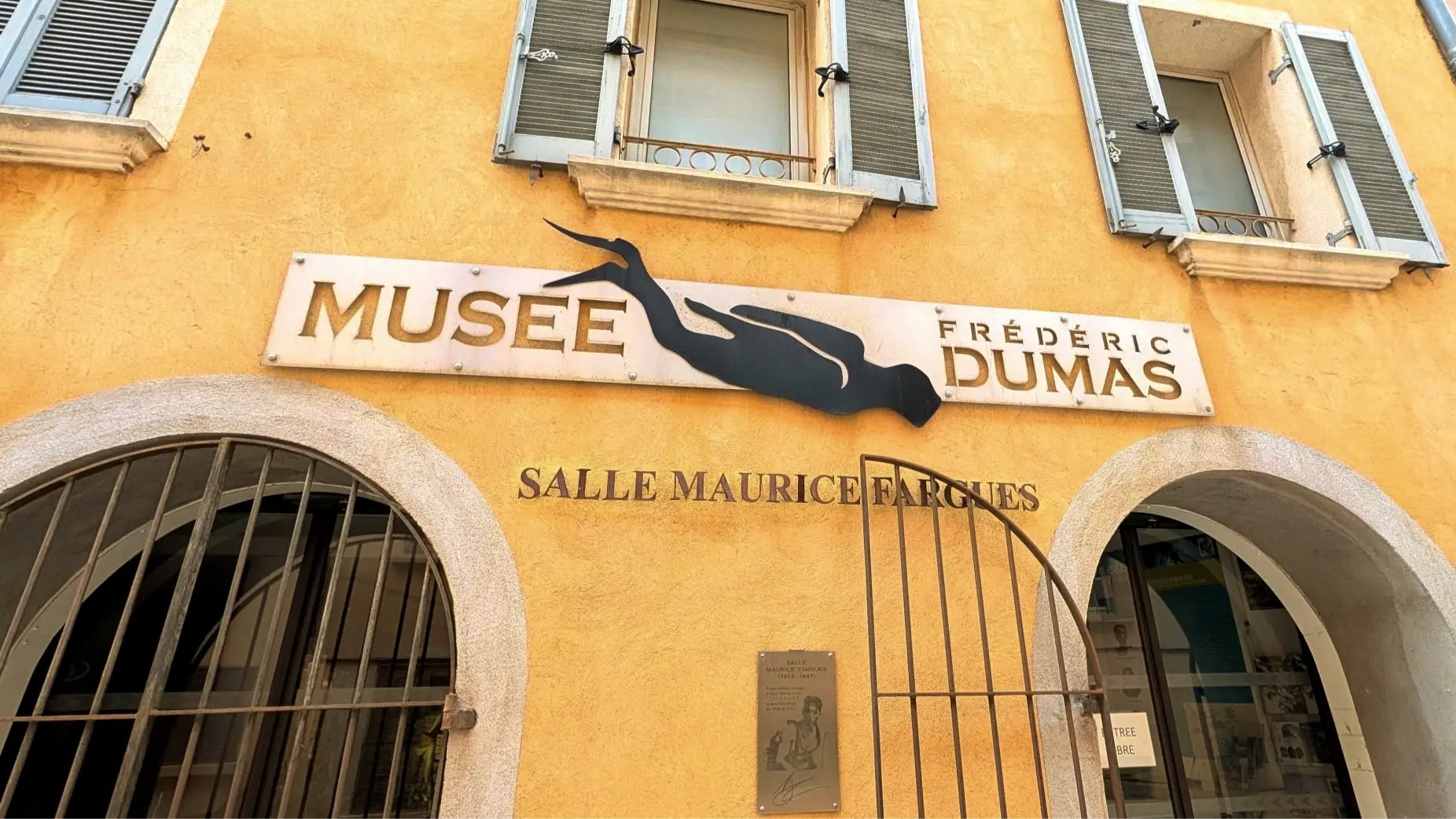 Sign for the Musée Frédéric-Dumas and Salle Maurice Fargues on the ochre tower in Sanary-sur-Mer